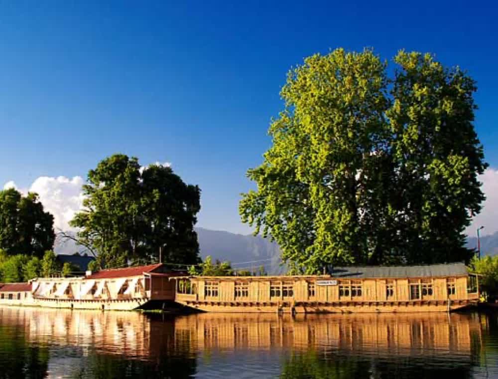 Houseboats reflected in the still water of Dal Lake at golden hour