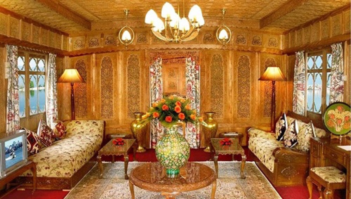 Carved walnut-wood interior of a Dal Lake houseboat with lamps and roses